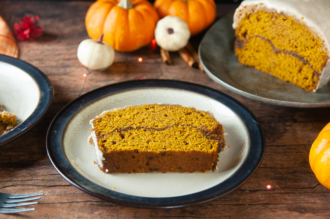 Cinnamon Swirl Pumpkin Bread sits on a brown rimmed plate waiting to be eaten!