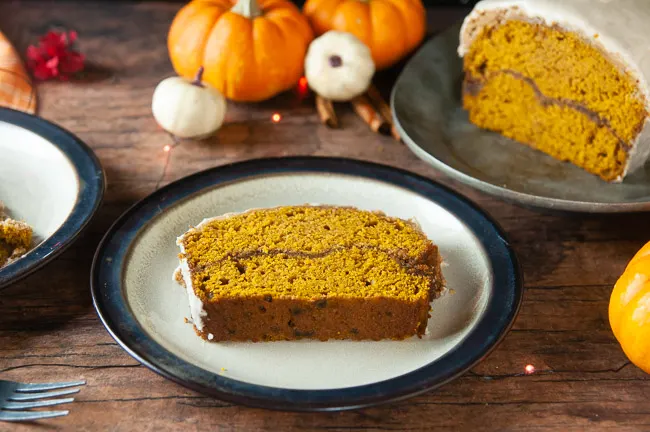 Cinnamon Swirl Pumpkin Bread sits on a brown rimmed plate waiting to be eaten!
