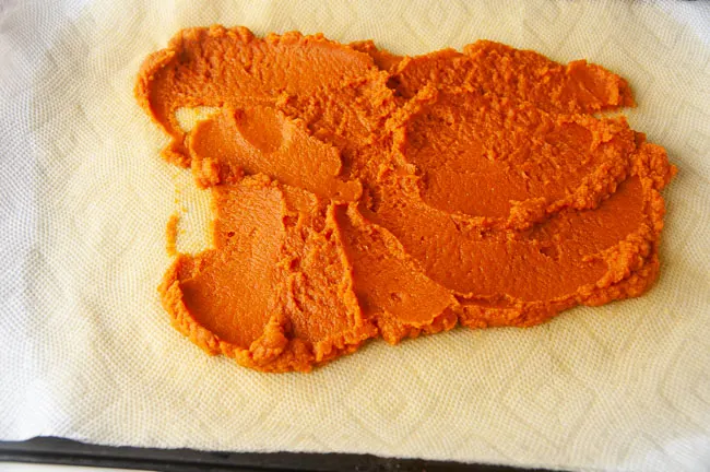 Pumpkin puree spread out on paper towels to drain of the excess moisture