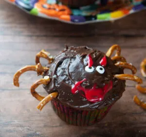 A spider cupcake with a red smile and eyebrows.