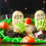 Spooky Graveyard Brownies are a fun food craft to do with the kids this Halloween. Cookies become tombstones and cookie crumbs, spooky sprinkles and edible zombie hands act as decorations.