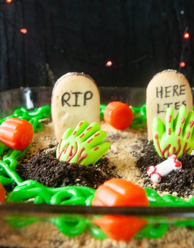 Spooky Graveyard Brownies are a fun food craft to do with the kids this Halloween. Cookies become tombstones and cookie crumbs, spooky sprinkles and edible zombie hands act as decorations.