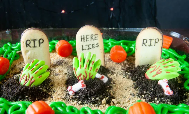 Spooky Graveyard Brownies are a fun food craft to do with the kids this Halloween. Cookies become tombstones and cookie crumbs, spooky sprinkles and edible zombie hands act as decorations.