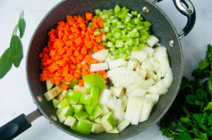 A large pan full of equal parts carrots, celery, onions, and apples