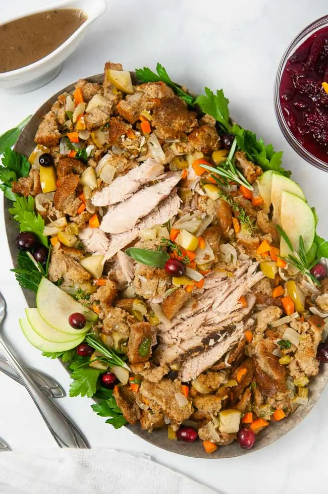 A platter of turkey surrounded by apple sage stuffing 
