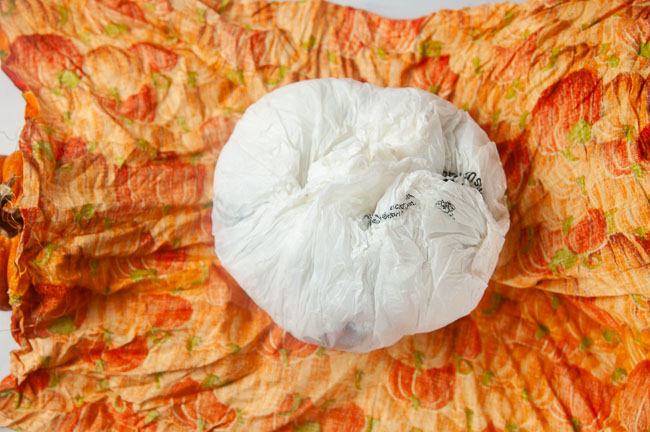 A square of fabric around a balled up bunch of plastic grocery bag
