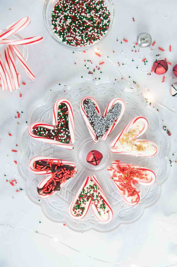 A festive spread featuring easy candy cane hearts on a white counter with sprinkles and candy canes