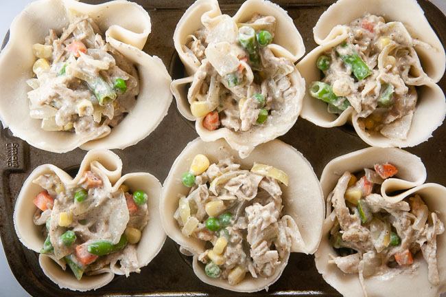A tray of unbaked mini chicken pot pie muffins