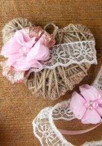 A DIY twine heart craft is a lovely decoration for Valentine's Day, spring, weddings or even Christmas. The rustic farmhouse decor is shown with lace and floral embellishments on wood.