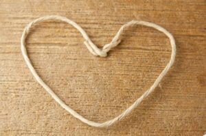 Shape the floral wire stem into a heart shape. Floral wire stem shaped like a heart on wood.