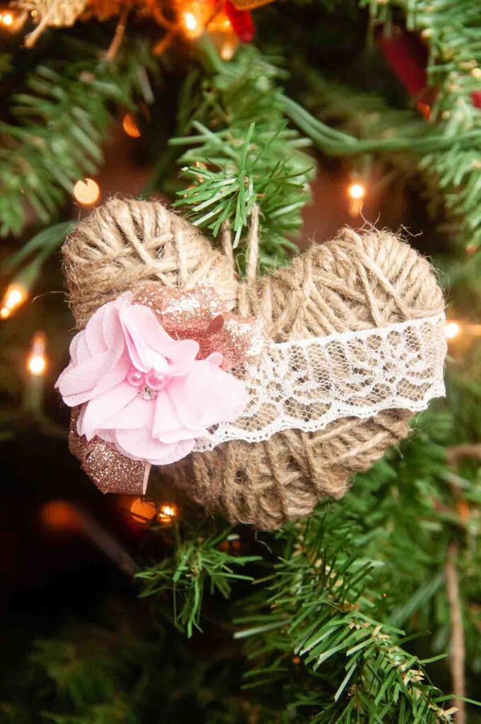 A twine heart hanging from a Christmas tree.