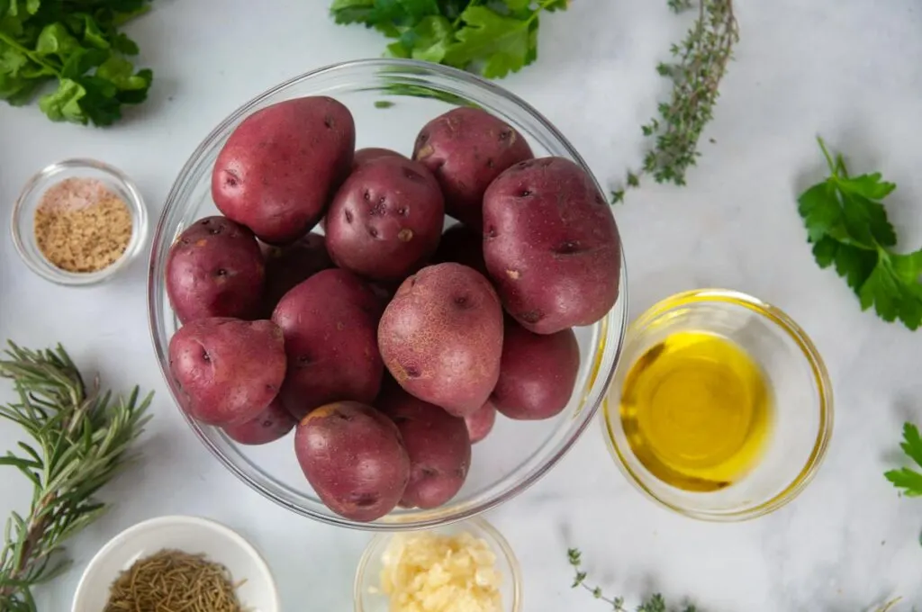 Ingredients for garlic herb potatoes: red potatoes, olive oil, spice, garlic, fresh herbs