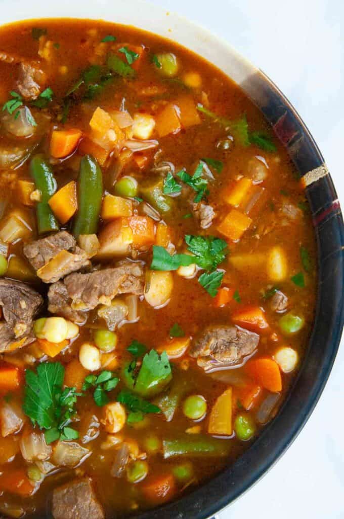 A bowl of hearty Instant Pot vegetable beef soup ready for a cozy dinner on a white background.