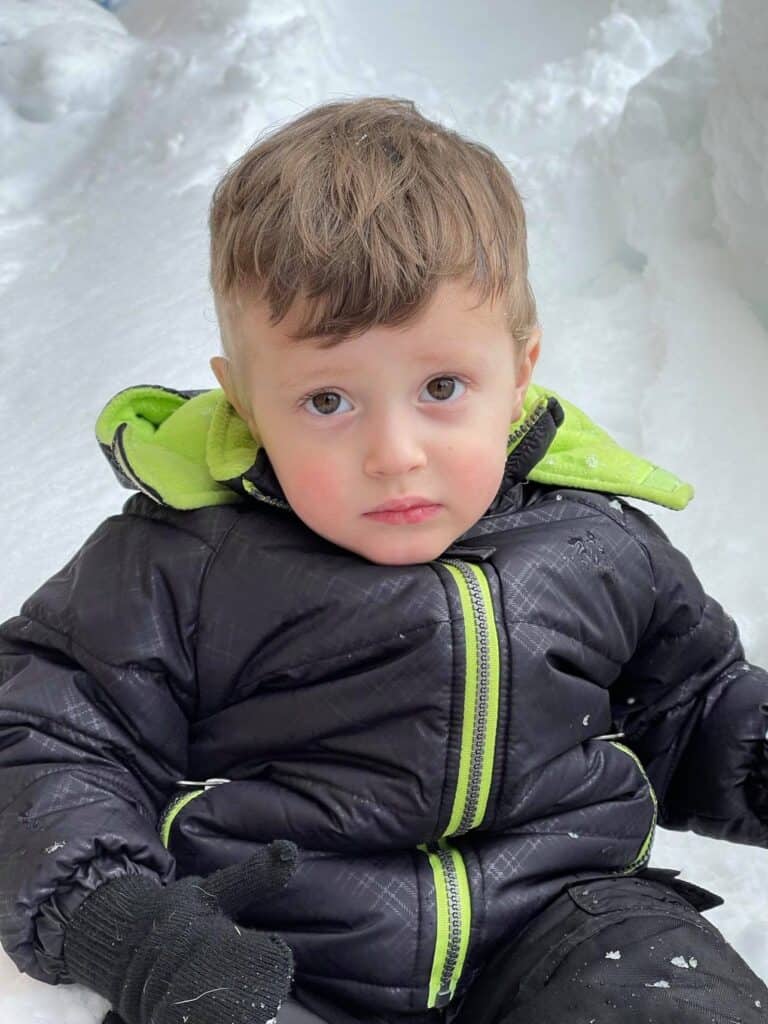 cranky toddler sitting in snow