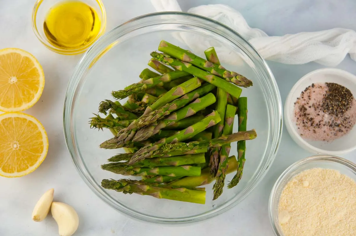 Ingredients for Air Fryer Asparagus: Trimmed asparagus, parmesan cheese, salt and pepper, lemon, olive oil and garlic