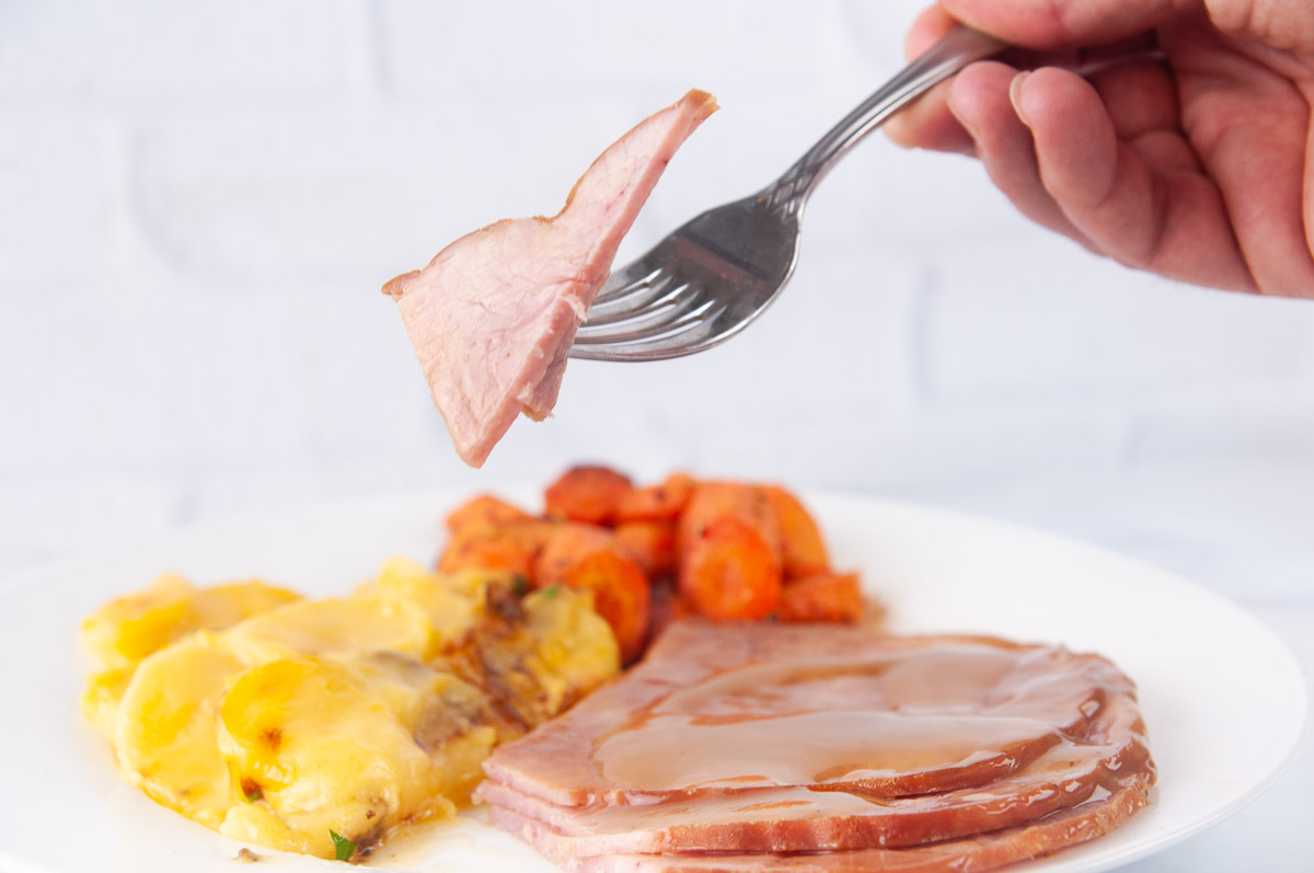 A forkful of Instant Pot ham with a sweet and savory glaze.