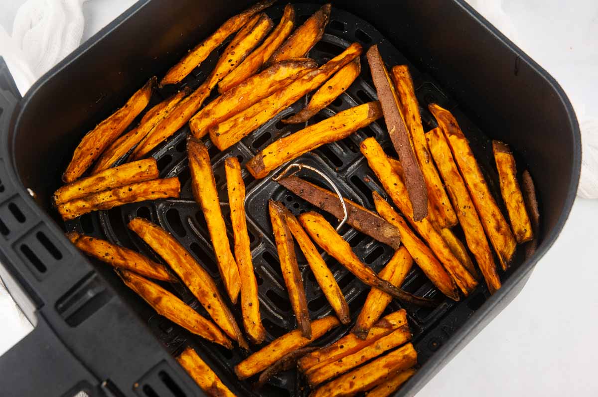 Cooked sweet potato fries in an air fryer basket