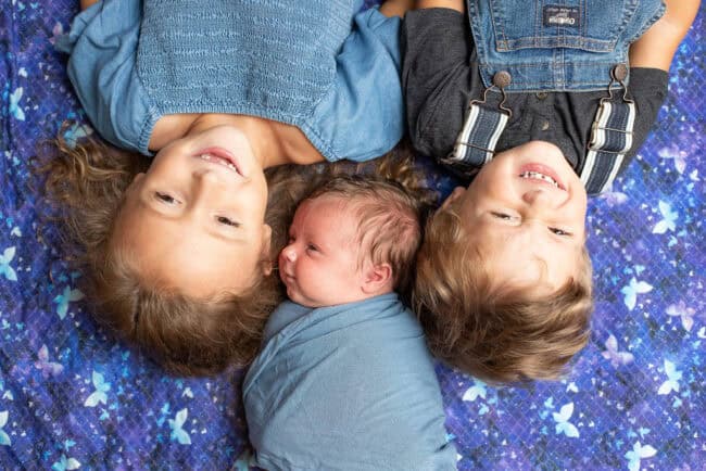 3 kids on a blue blanket