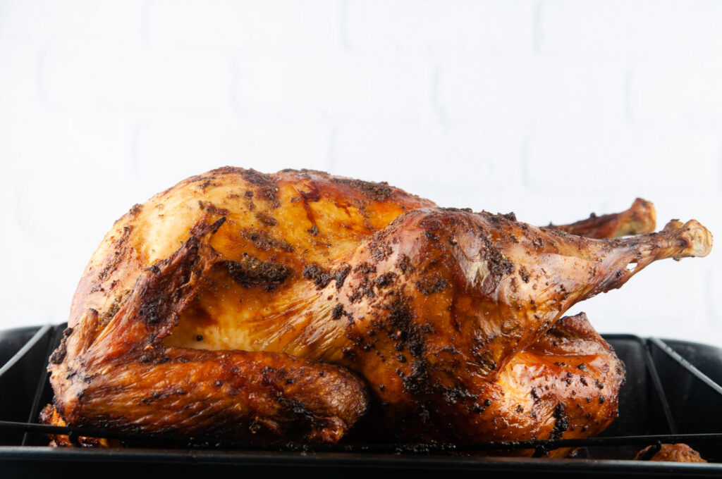 The garlic butter basted turkey out of the oven fully cooked and beautifully golden brown/