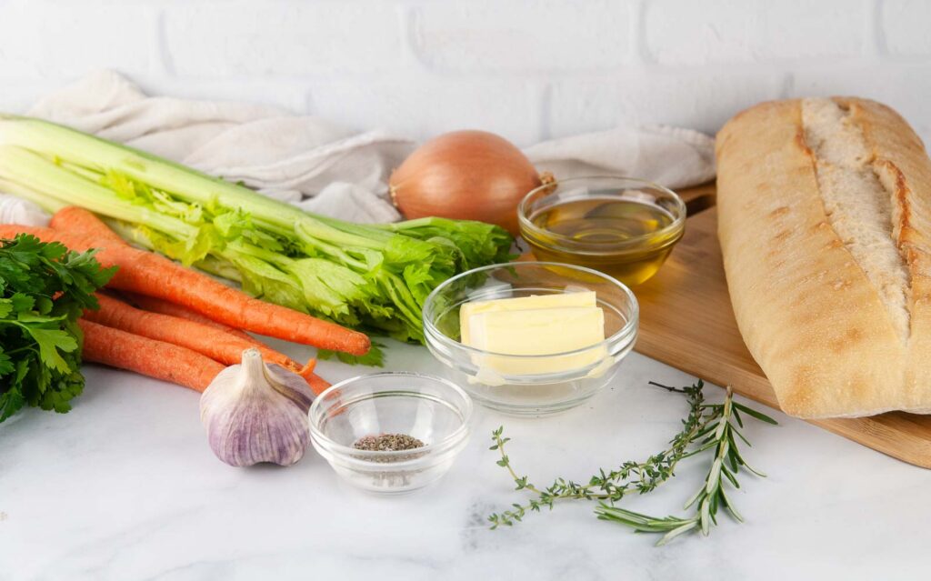 Ingredients for Garlic Herb Ciabatta Stuffing: bread, herbs, butter, carrots, celery, onions, garlic, and olive oil