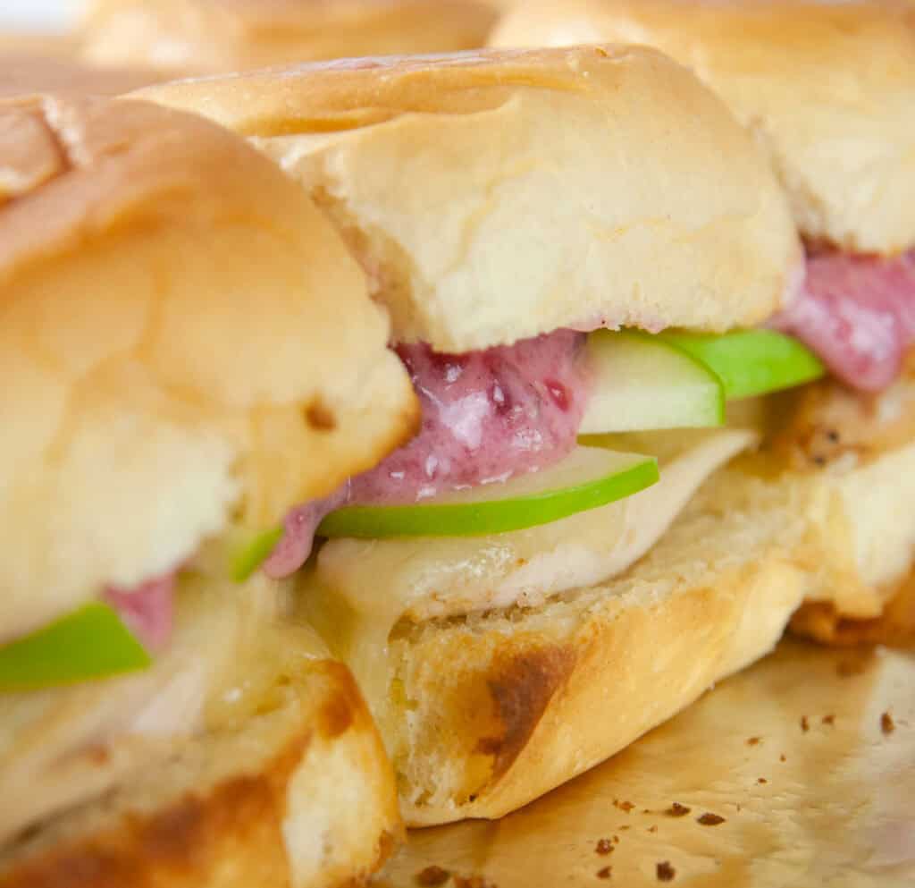 Turkey sliders on Hawaiian rolls are loaded with cranberry mayo, sharp cheddar and tart apple slices for a yummy way to use up holiday leftovers.