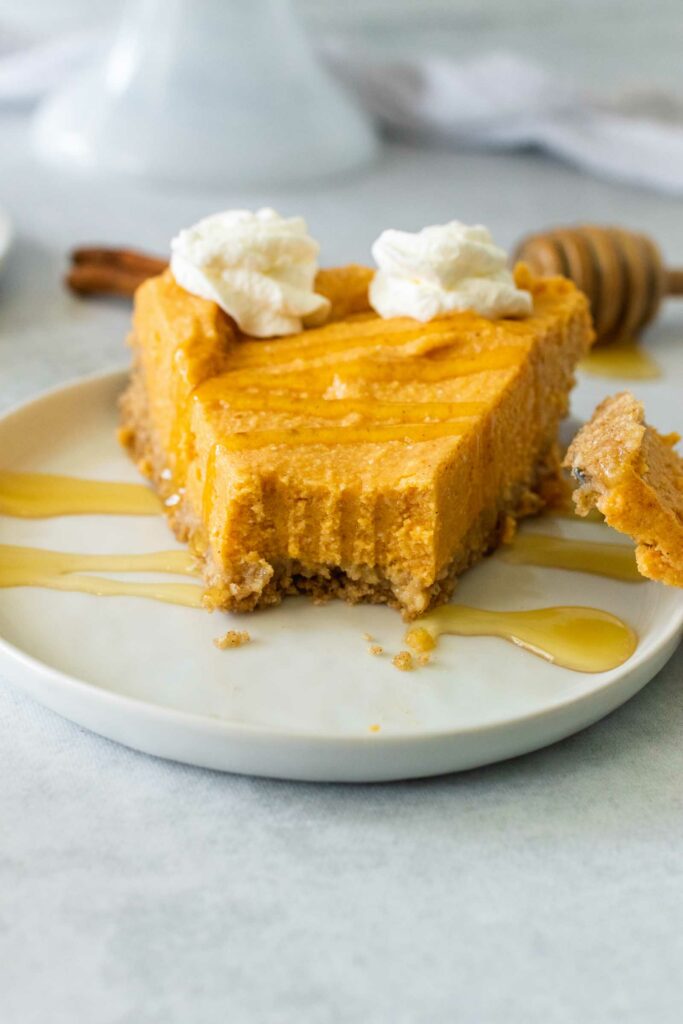 No Bake Pumpkin Cheesecake makes a perfect easy fall or holiday dessert. A bite taken out of a slice of cheesecake.