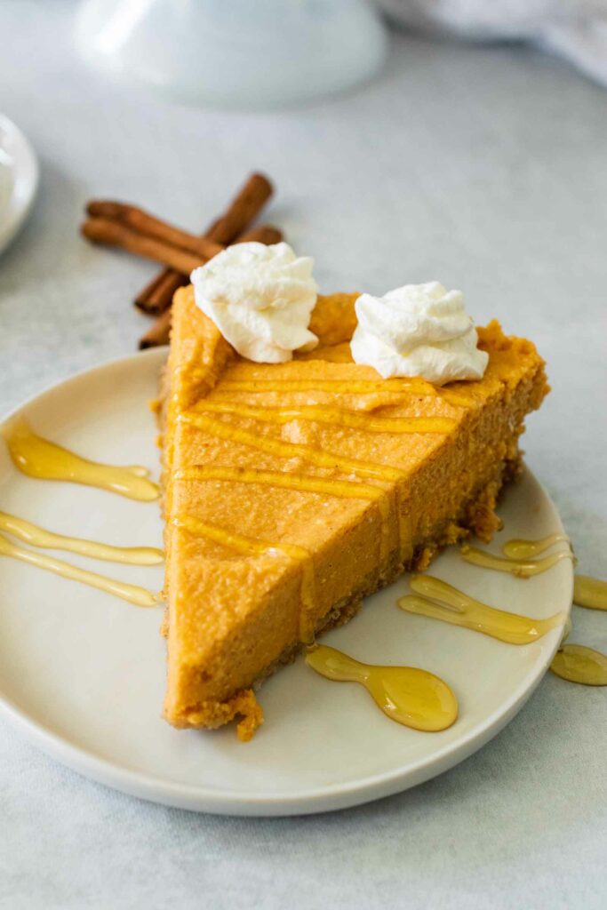 A perfect slice of no bake pumpkin cheesecake drizzled with honey is a delicious holiday or fall dessert.