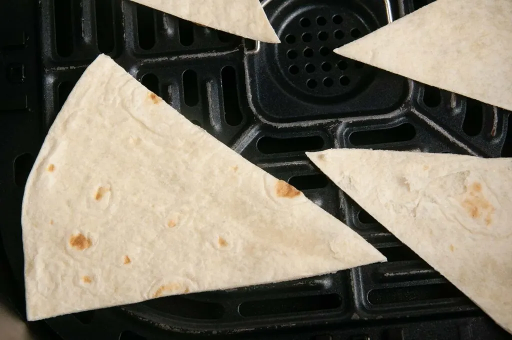 Add the cut tortillas to the basket of your air fryer.