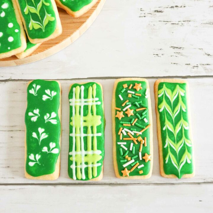 A spread of St. Patrick's Day Sugar Cookies decorated in different designs with royal icing