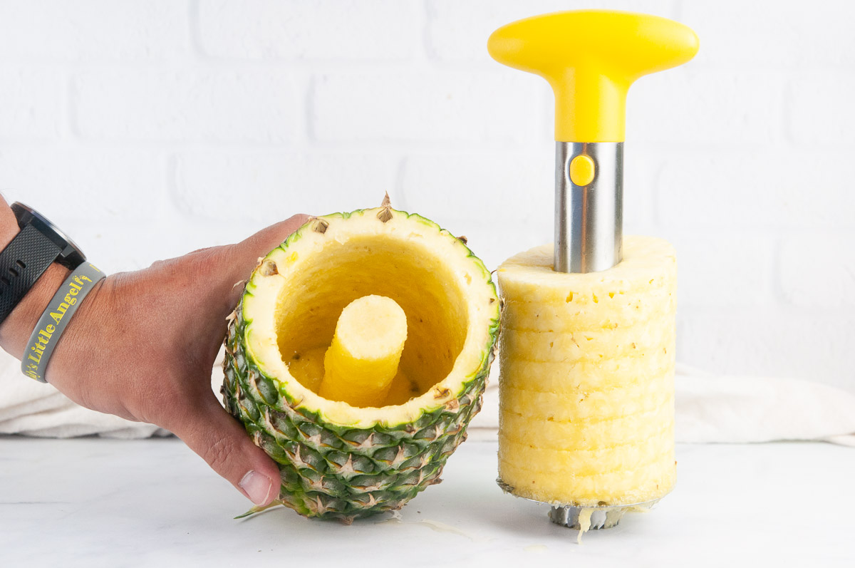 A cored pineapple with a pineapple corer