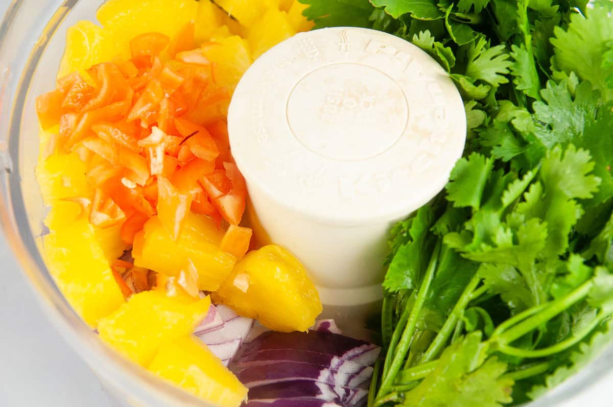 Put all the fruit, veggies, and herbs into a food processor.