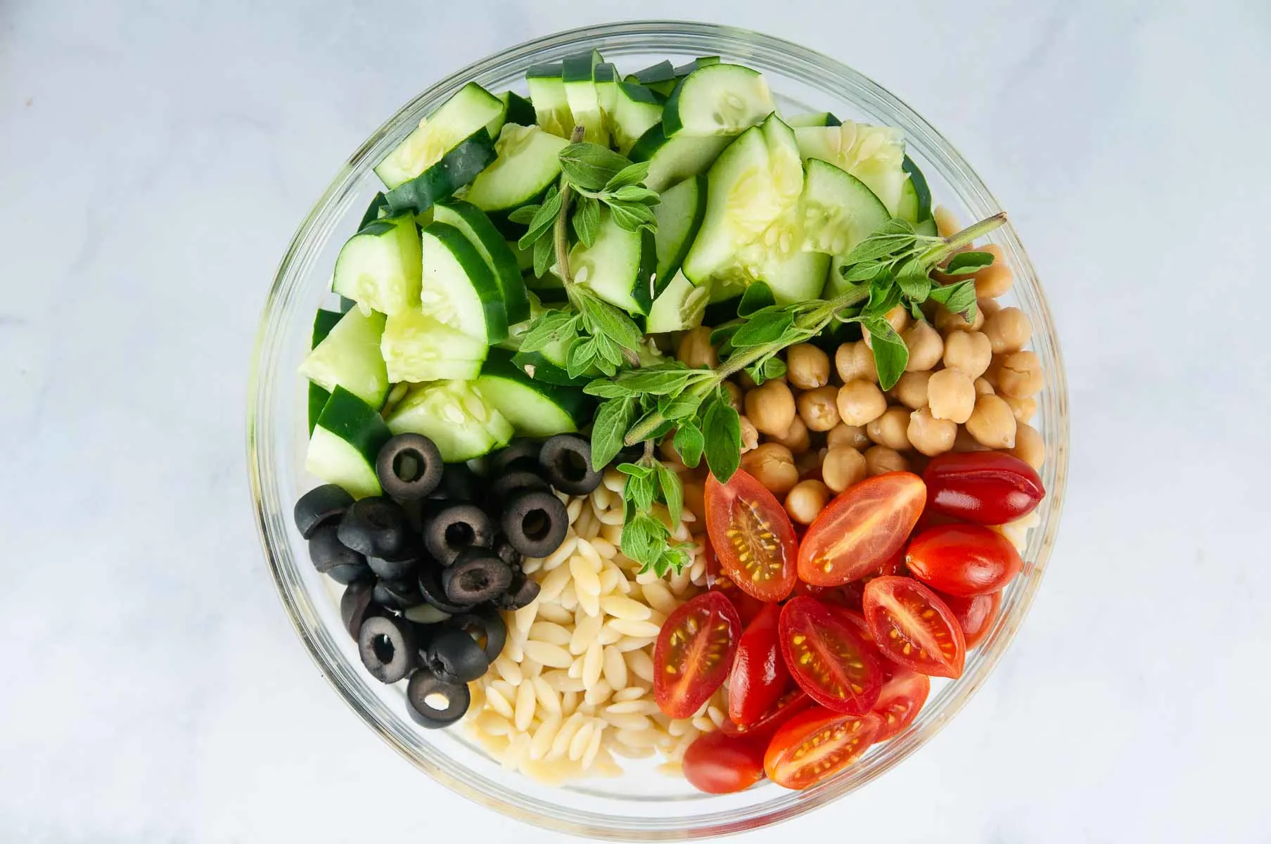 Add the prepared veggies into a large bowl with the cooked, cooled orzo