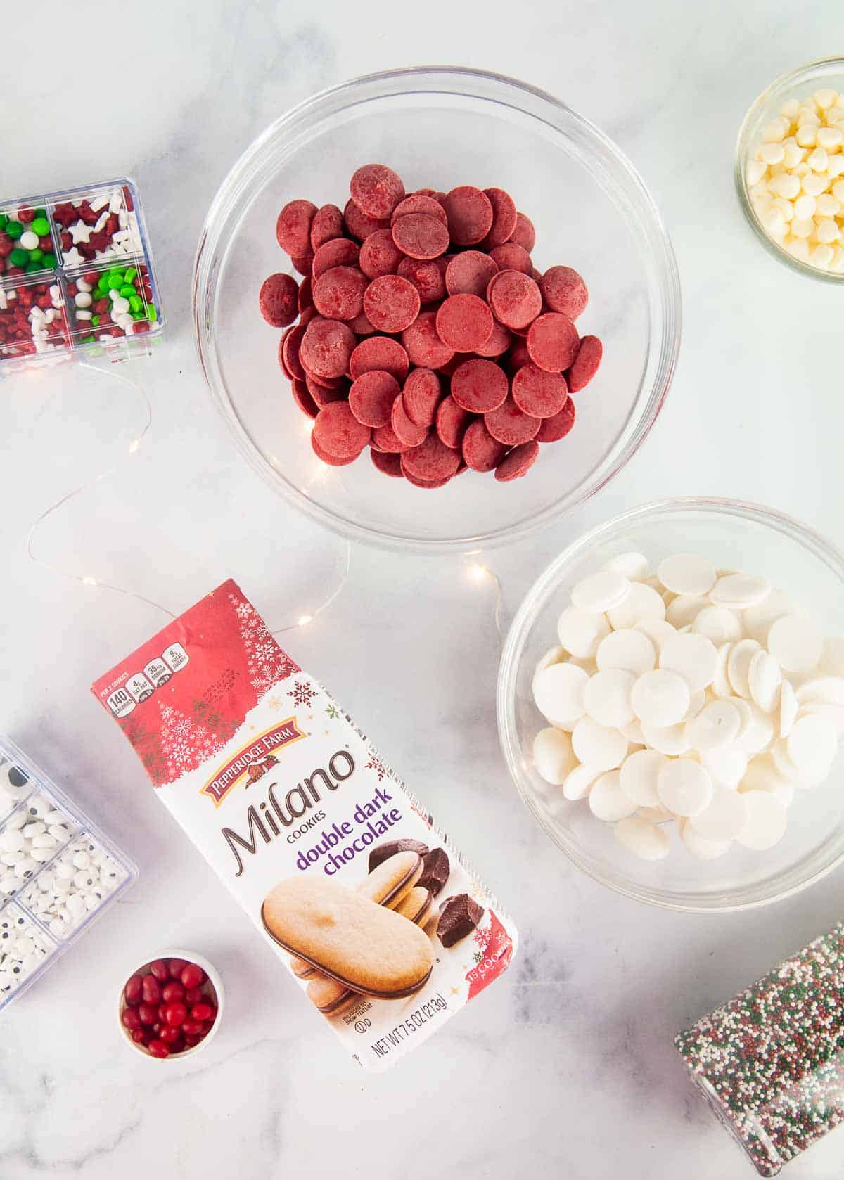 Ingredients for Easy Santa Cookies: Milanos, candy melts, sprinkles, candy eyes, and Red Hots