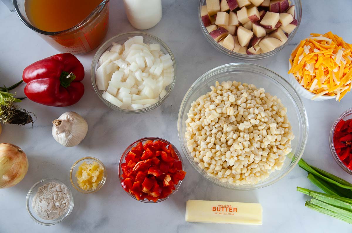 Ingredients for Instant Pot Corn chowder: corn, peppers, potatoes, cheese, flour, half and half, vegetable broth, butter, garlic, water
