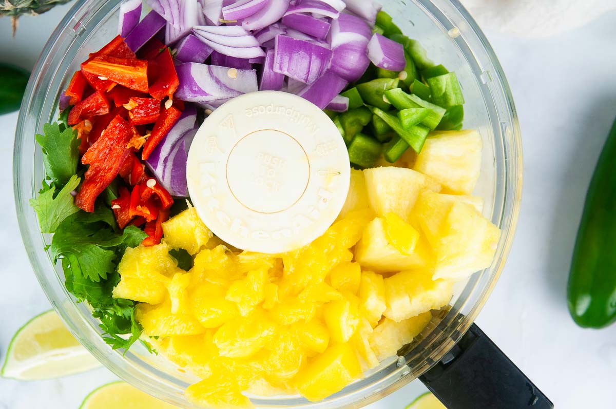 Add the chopped fruit and veggies into a food processor.