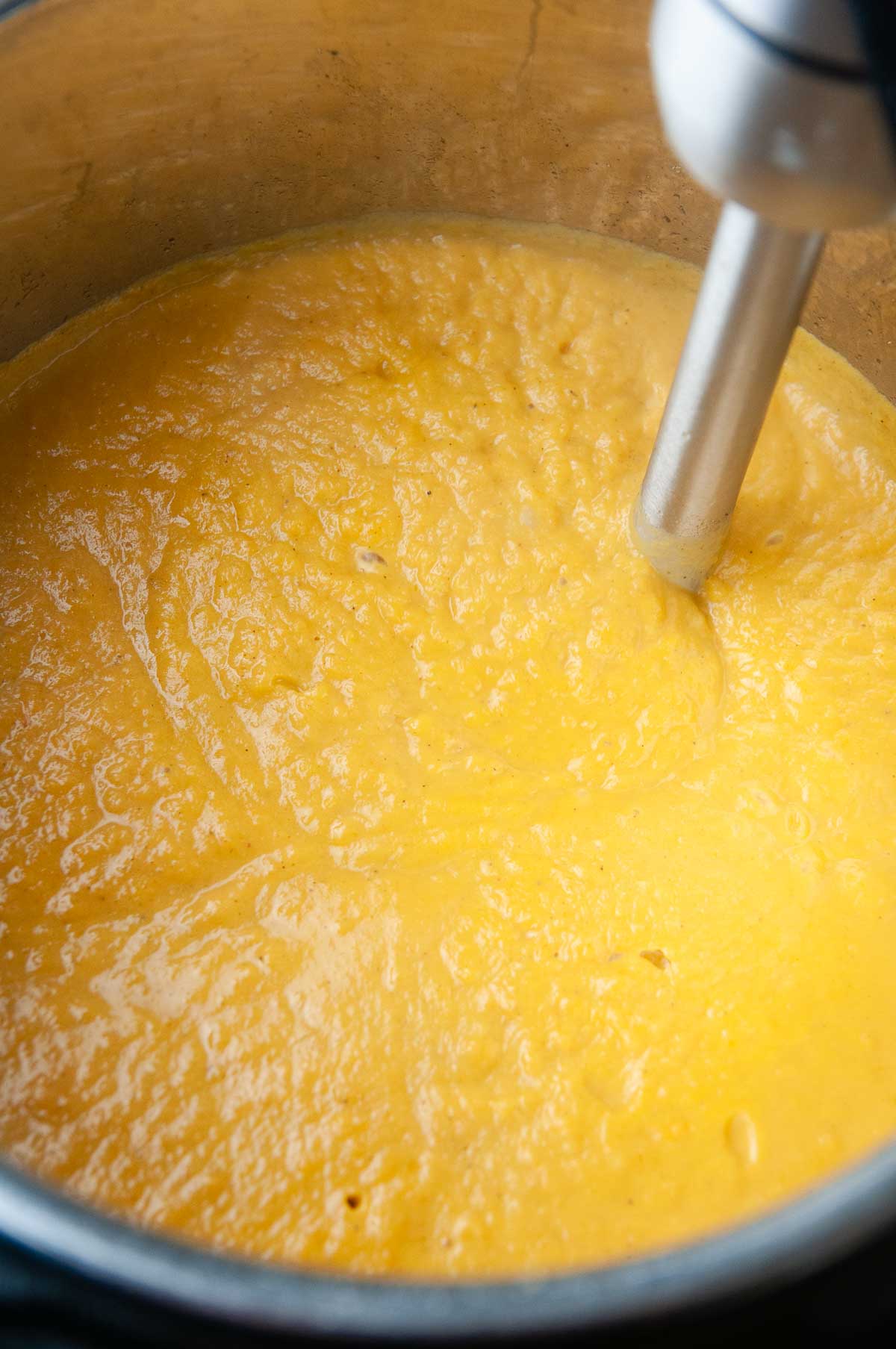 Puree the sweet potato and pumpkin soup with an immersion blender