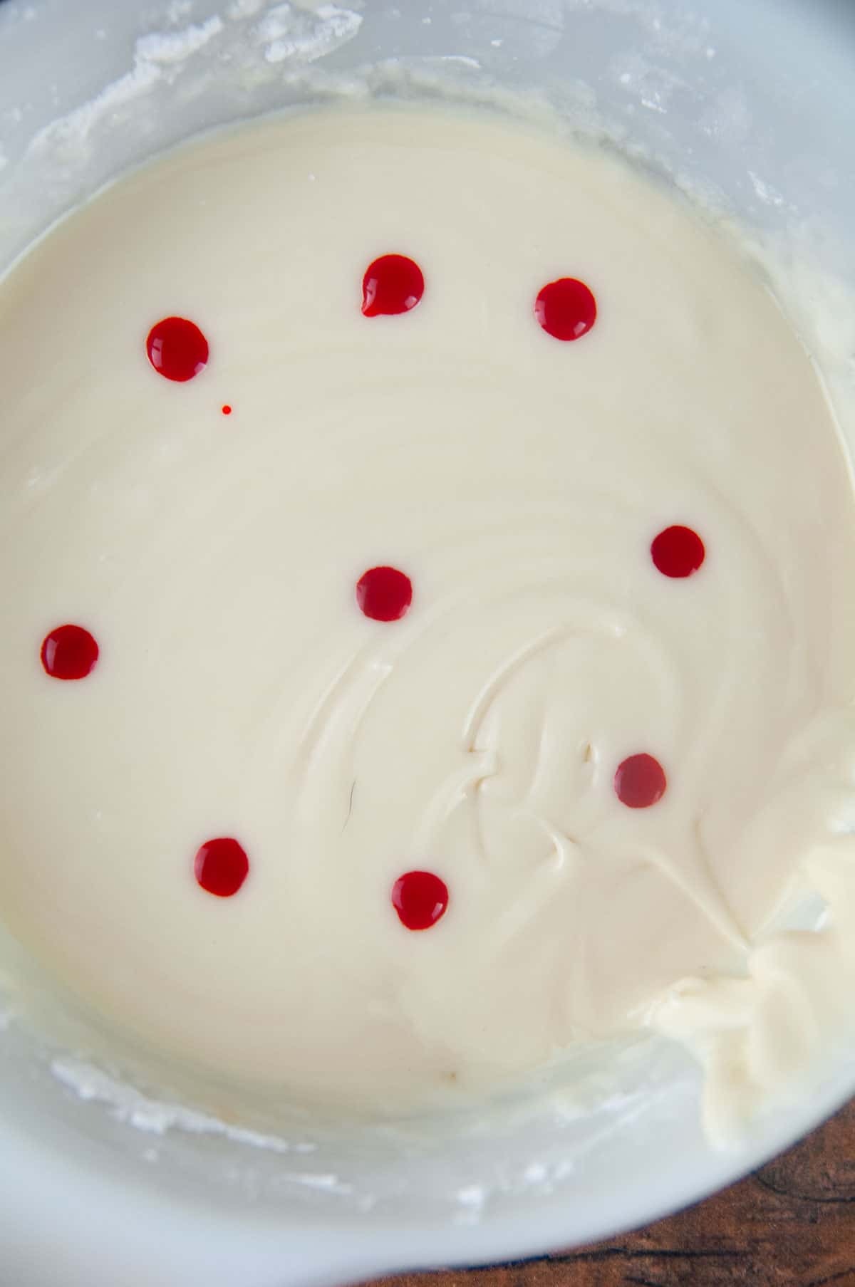 Dot drops of food coloring onto the surface of the sugar cookie icing.