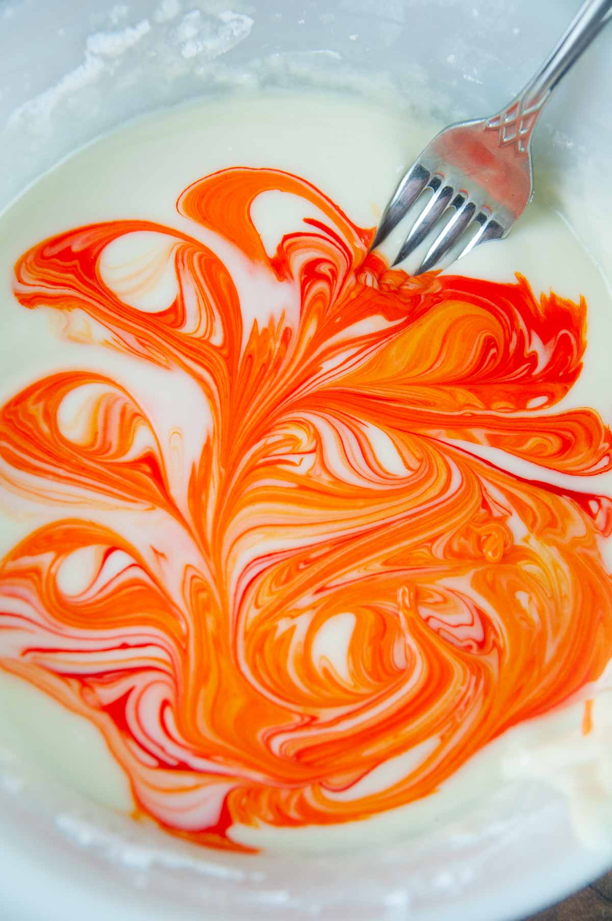 Drag a fork through the food coloring and icing to swirl it for a marbled effect.