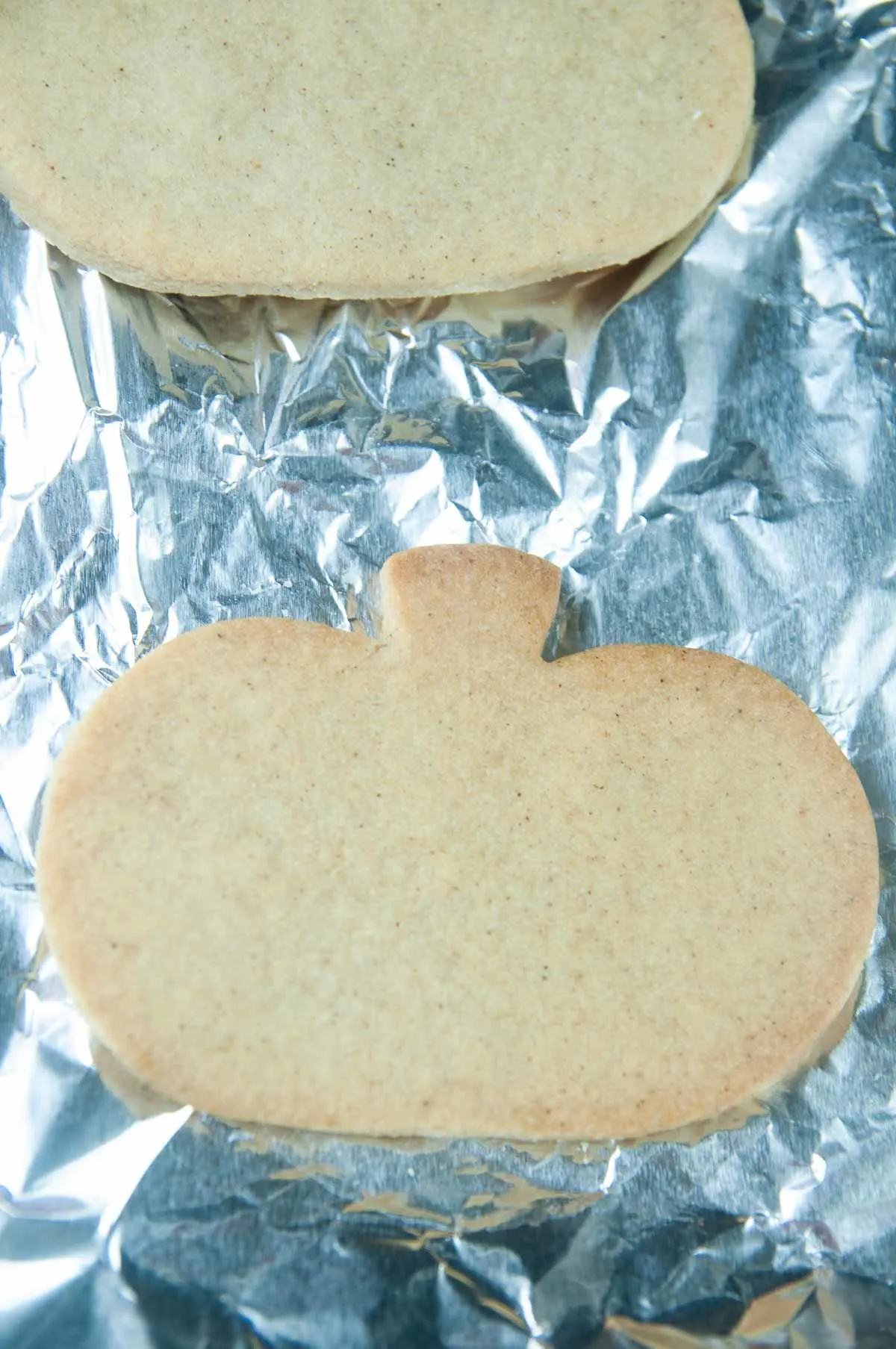 Baked Cut Out Pumpkin Spice Cookies on aluminum foil