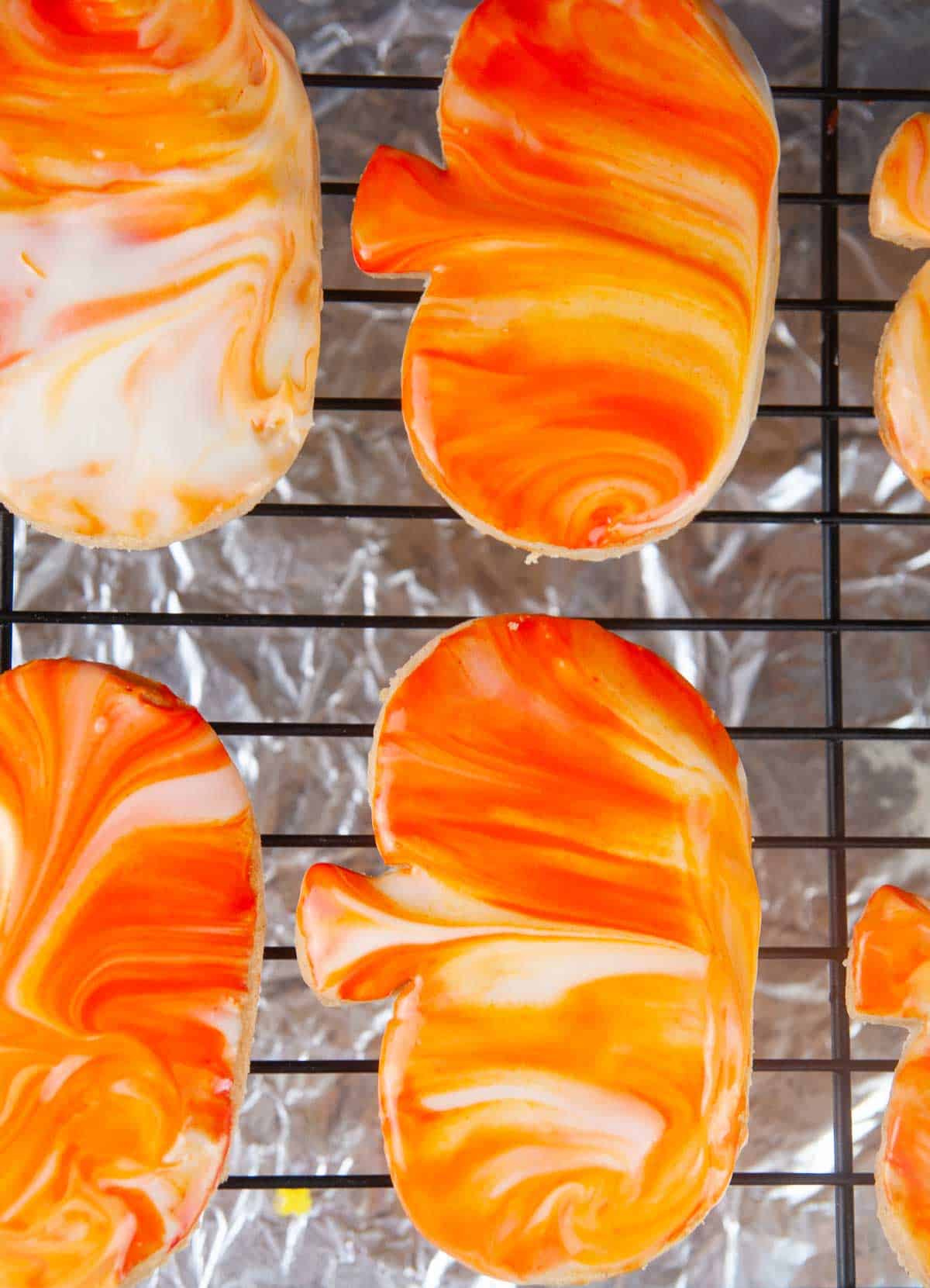 Marbling Cut Out Pumpkin Spice Cookies by dipping them in icing makes for quick and easy decorating!