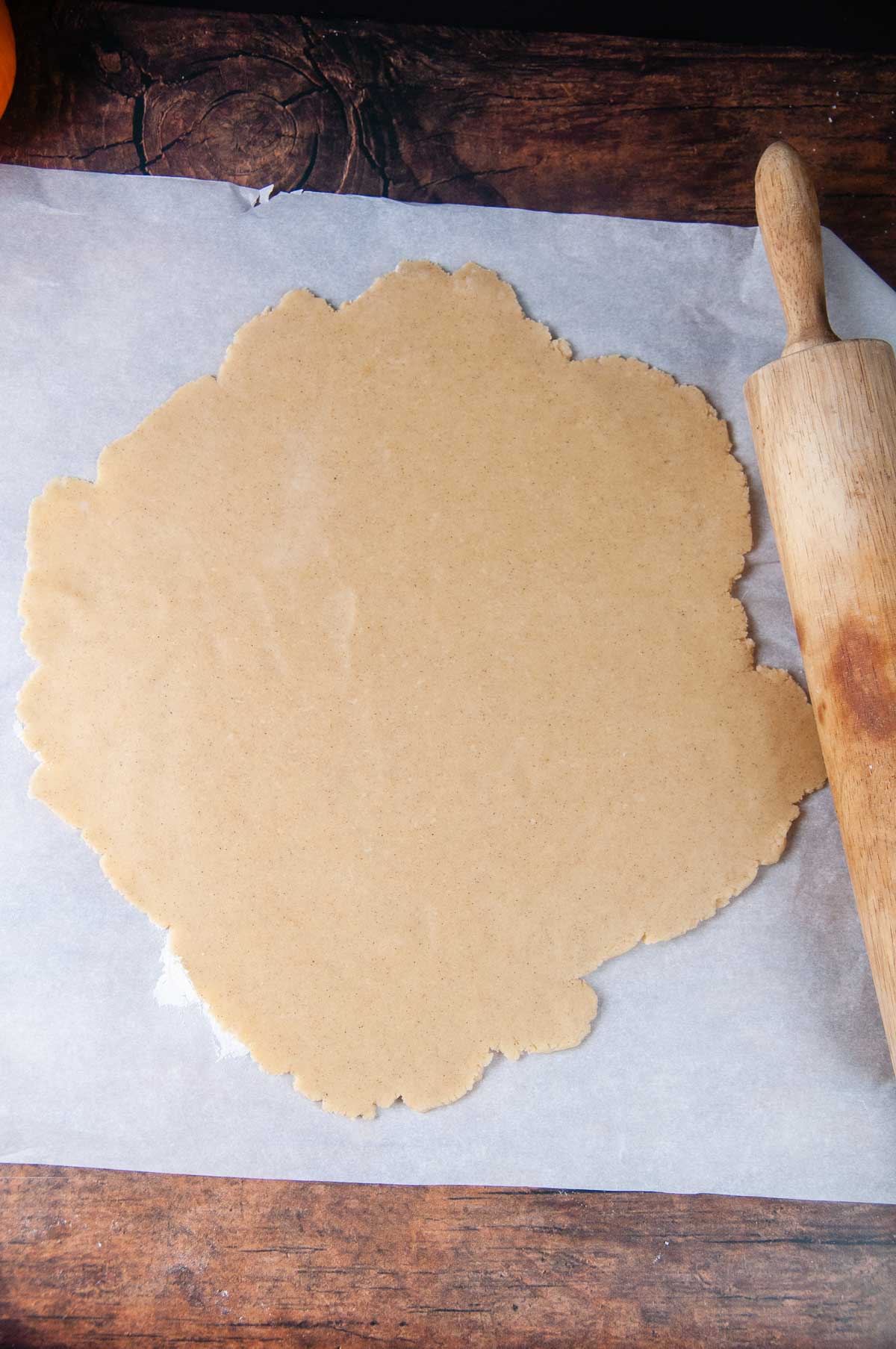 Roll out half of the pumpkin spice cookie dough on a sheet of parchment paper.