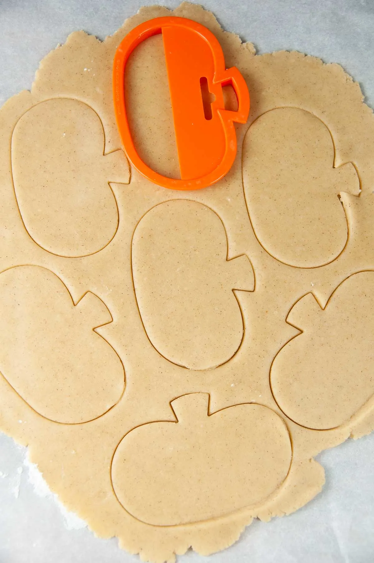 Cut the pumpkin sugar cookies out with a cookie cutter.