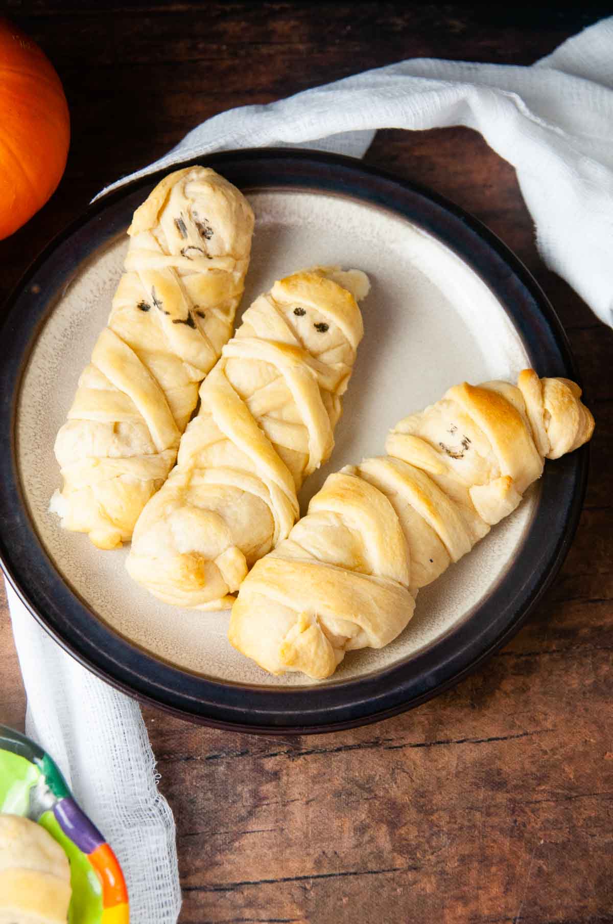 Mummy mozzarella sticks in crescent dough are an easy Halloween snack or appetizer both kids and adults love.
