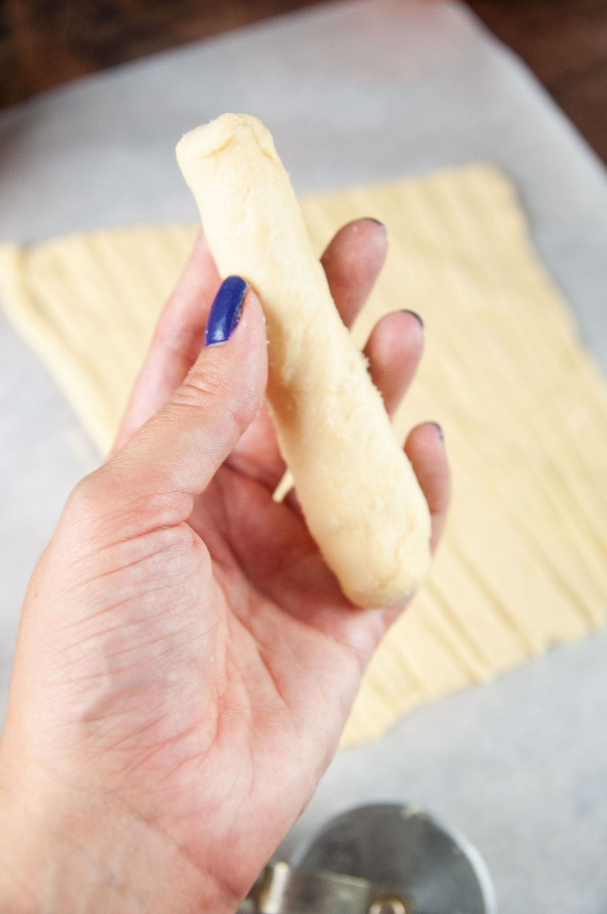 Wrap the frozen string cheese entirely in a thin layer of crescent dough