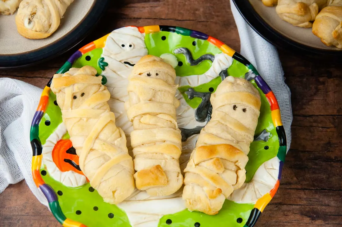 Mummy mozzarella sticks in crescent dough are an easy Halloween snack or appetizer both kids and adults love.