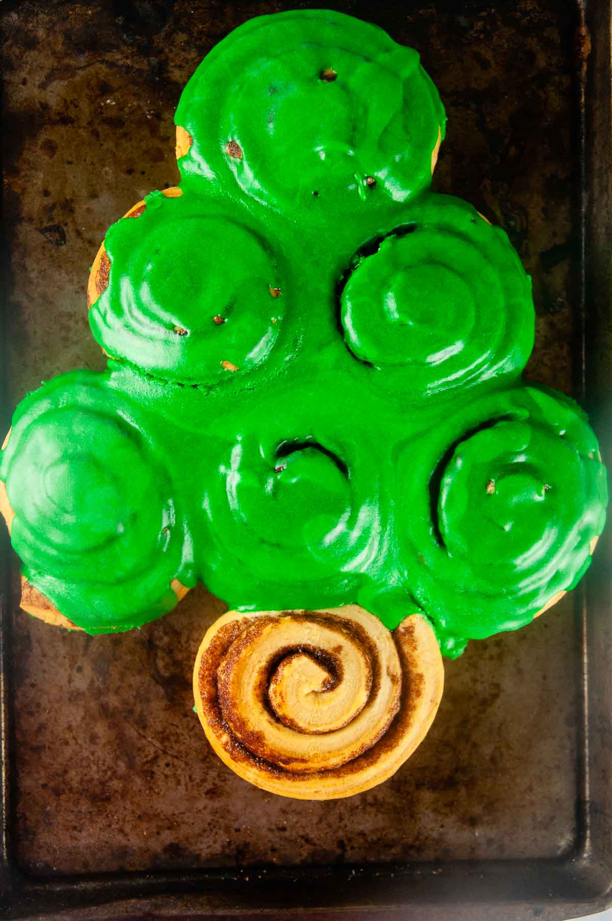 The cinnamon roll Christmas tree covered in green frosting ready for decorating!
