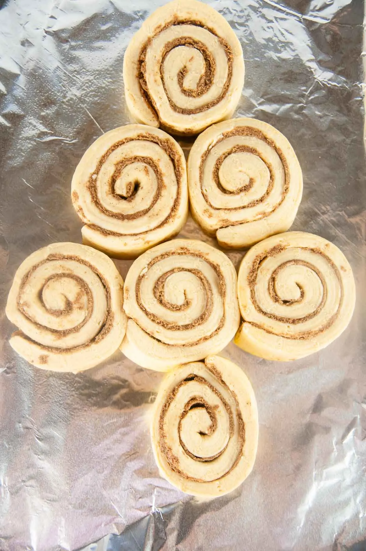 Arrange the cinnamon rolls on a baking sheet to look like a Christmas tree.