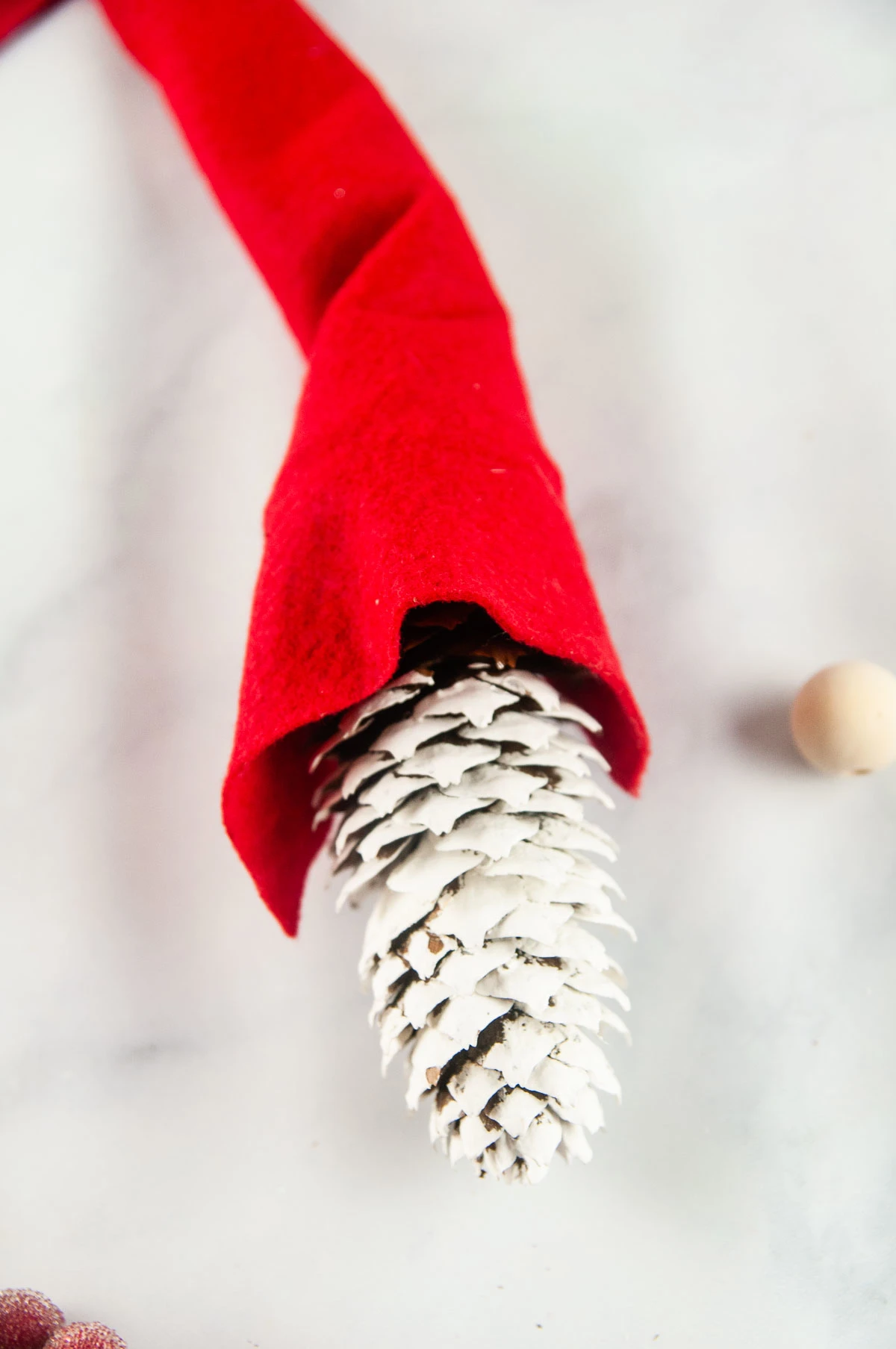 Stick the pinecone, unpainted side up, into the felt hat. Don't glue it down yet.