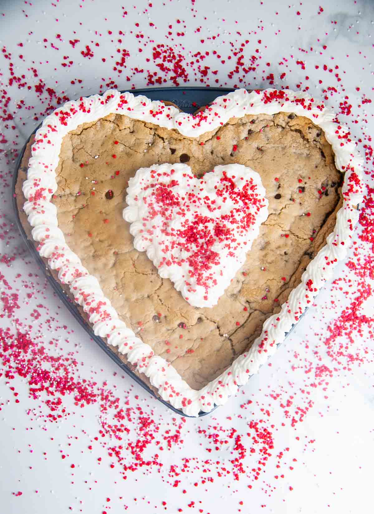 A giant heart shaped chocolate chip cookie cake is so easy to make and such a fun Valentine's Day dessert!