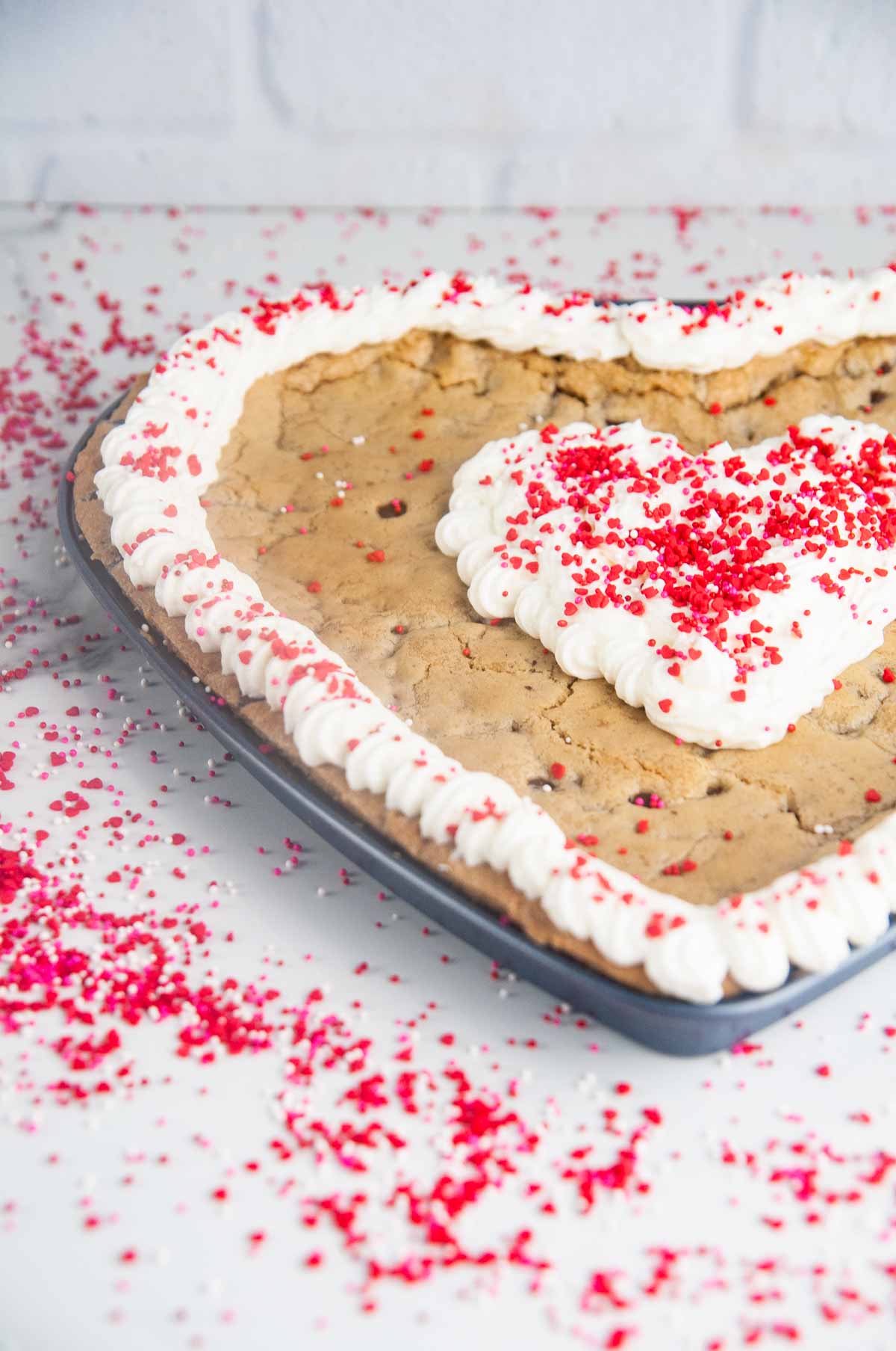 A giant heart shaped chocolate chip cookie cake is so easy to make and such a fun Valentine's Day dessert!